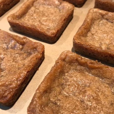 Photo of square blondies with Maldon sea salt on brown parchment paper